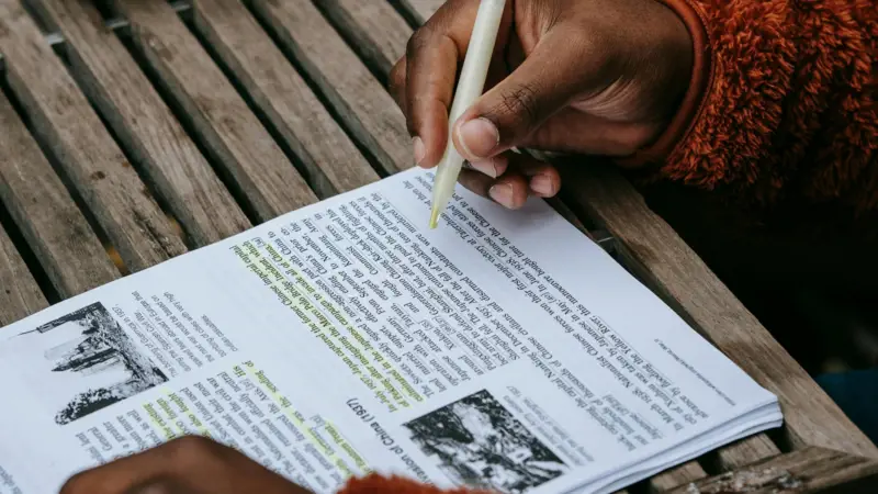 Como fazer um resumo: Dicas essenciais para saber como escrever um resumo 2 Como Fazer Resumo: mão escrevendo em um caderno com trechos destacados, exemplificando técnicas de resumo.